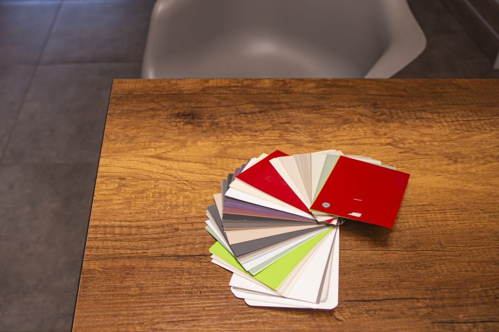 a color selection catalog lying on a table in the office of a furniture factory, against a blurred background of mdf furniture